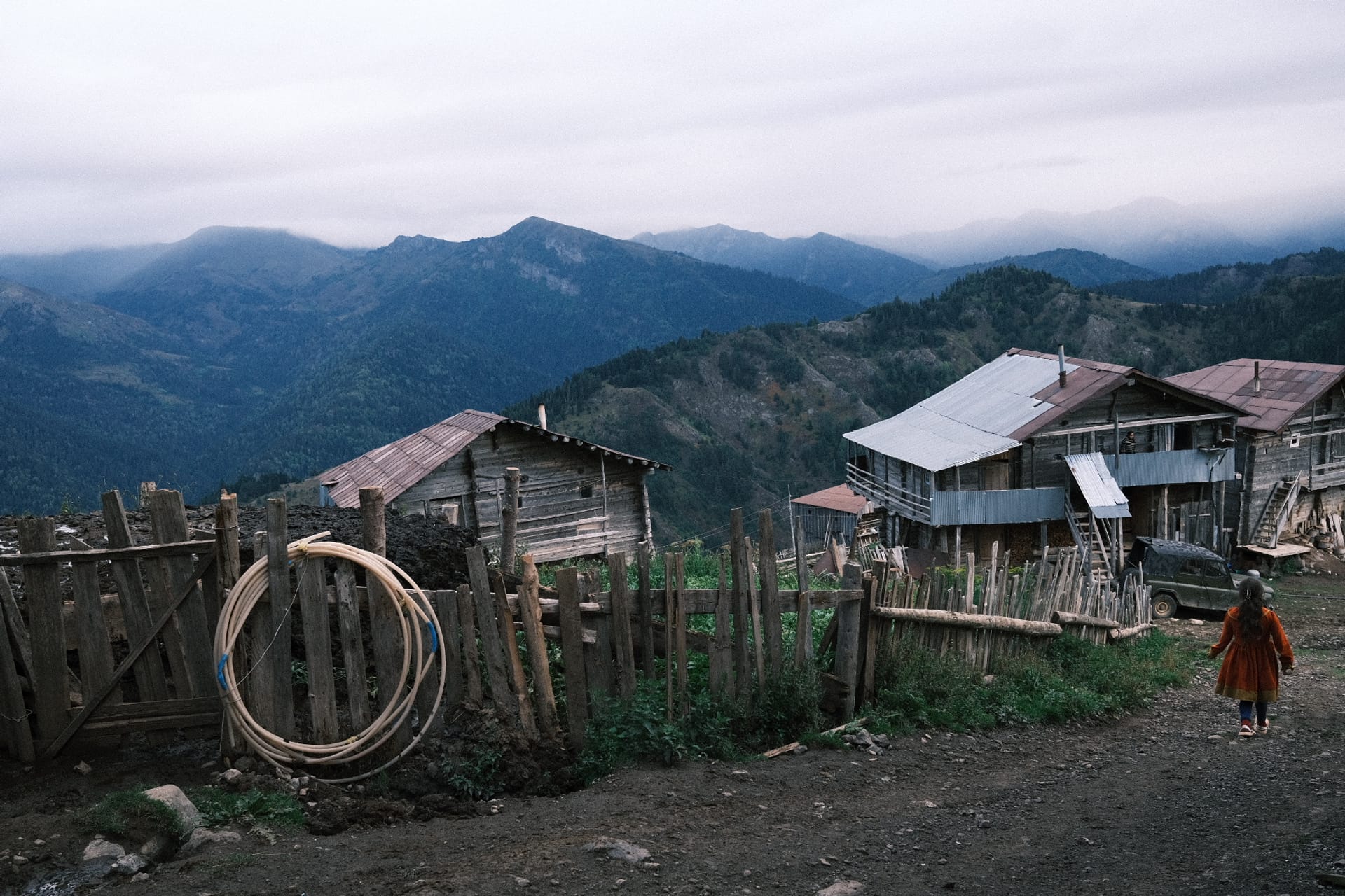A misty mountain village with tin-roofed wooden houses in the Georgian highlands