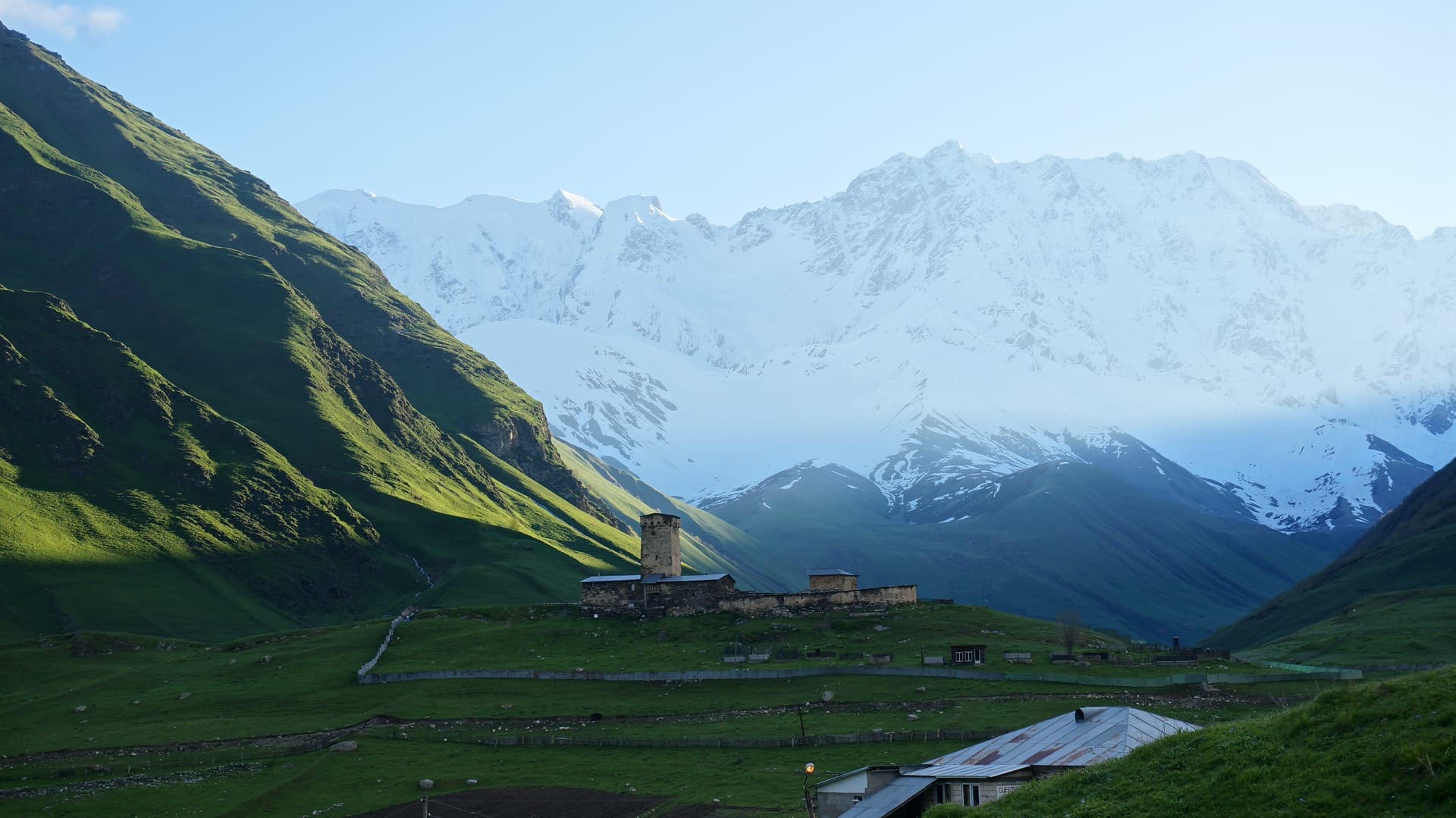 A stone defensive tower in Ushguli beneath the snow-capped peaks of Svaneti